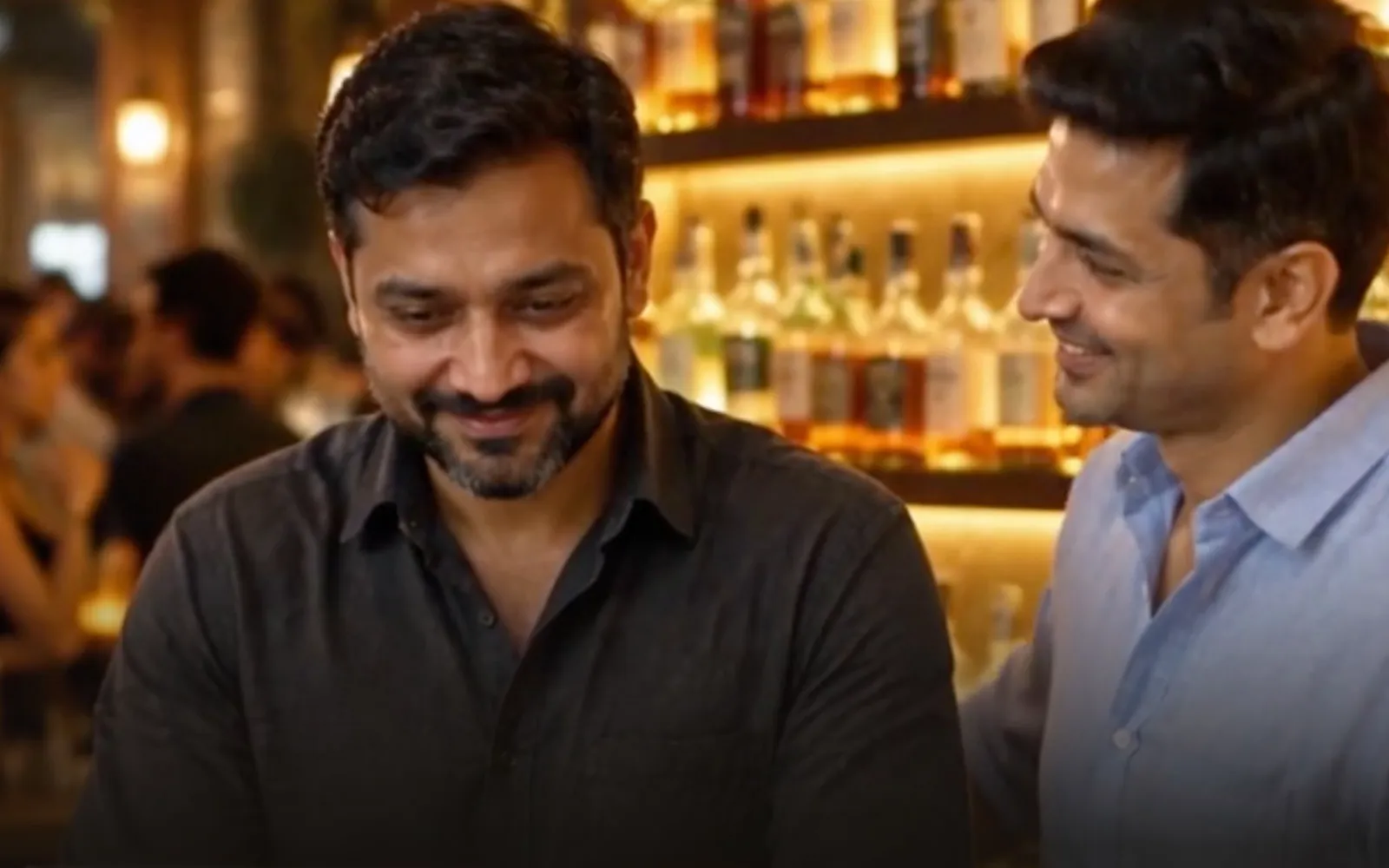 Two bar owners smiling together at the counter